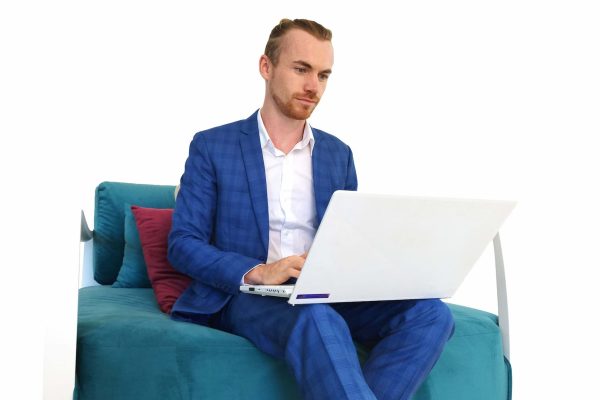 Joshua Reece sitting working on his laptop